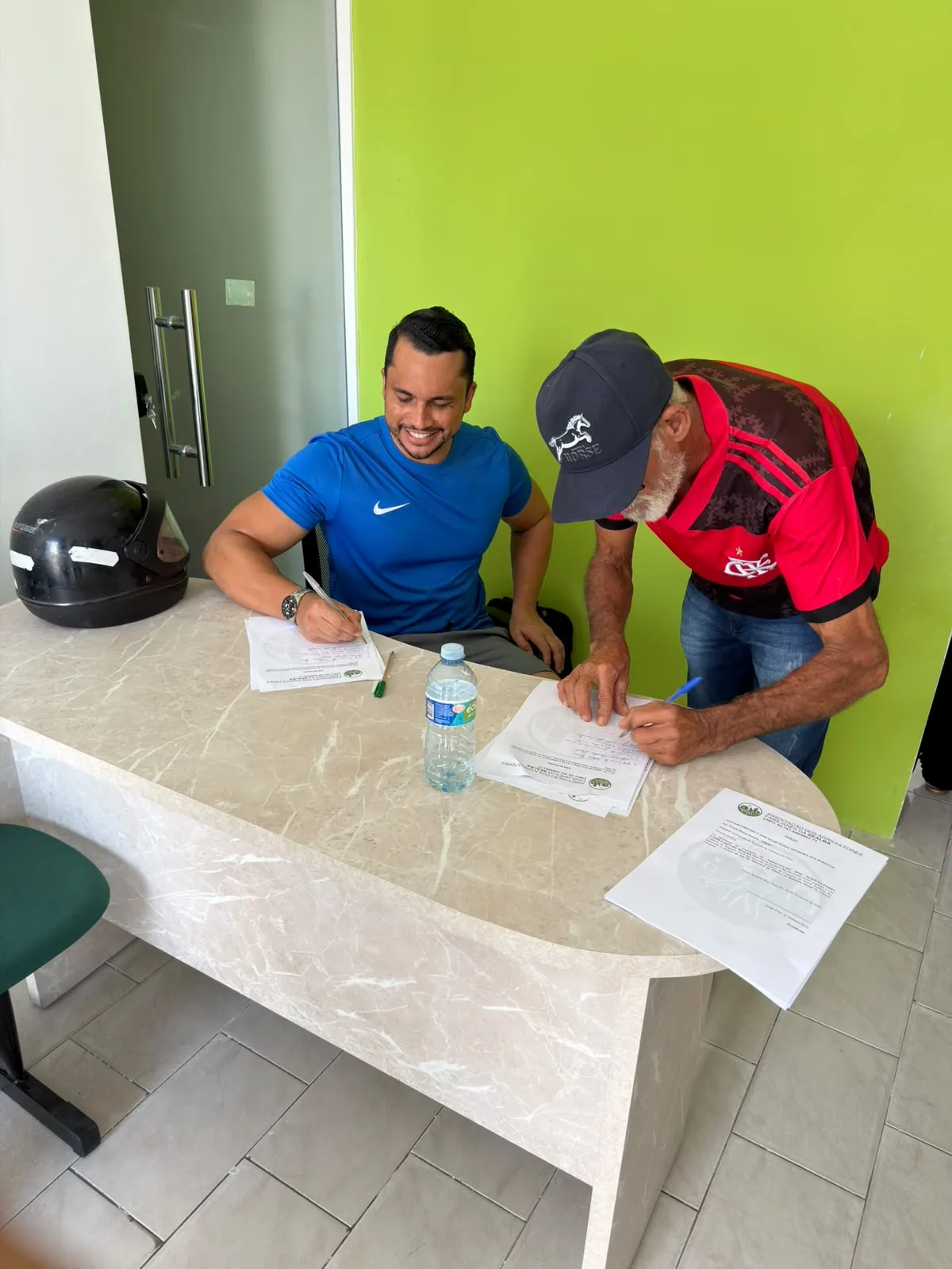 Participantes preenchendo documentos durante atendimento comunitário