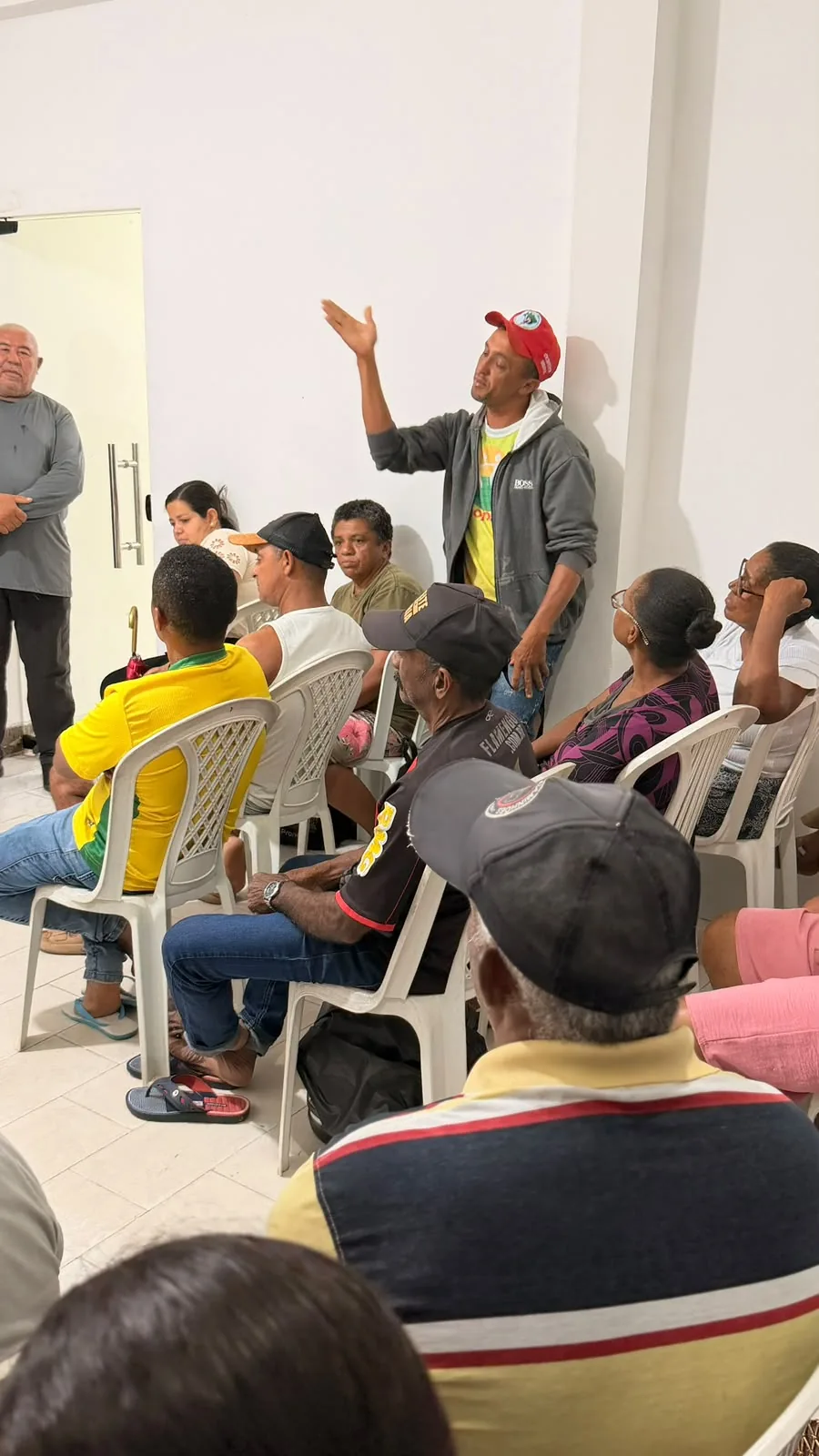 Participante em pé falando durante reunião comunitária